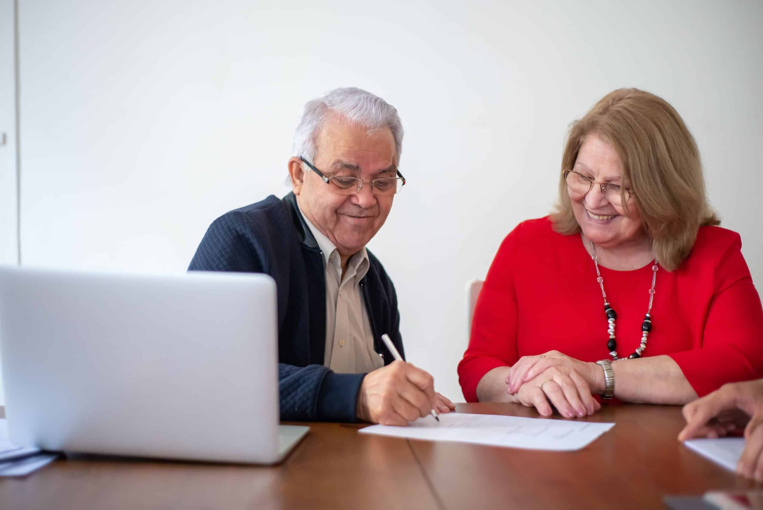 man and woman happily signing a document together