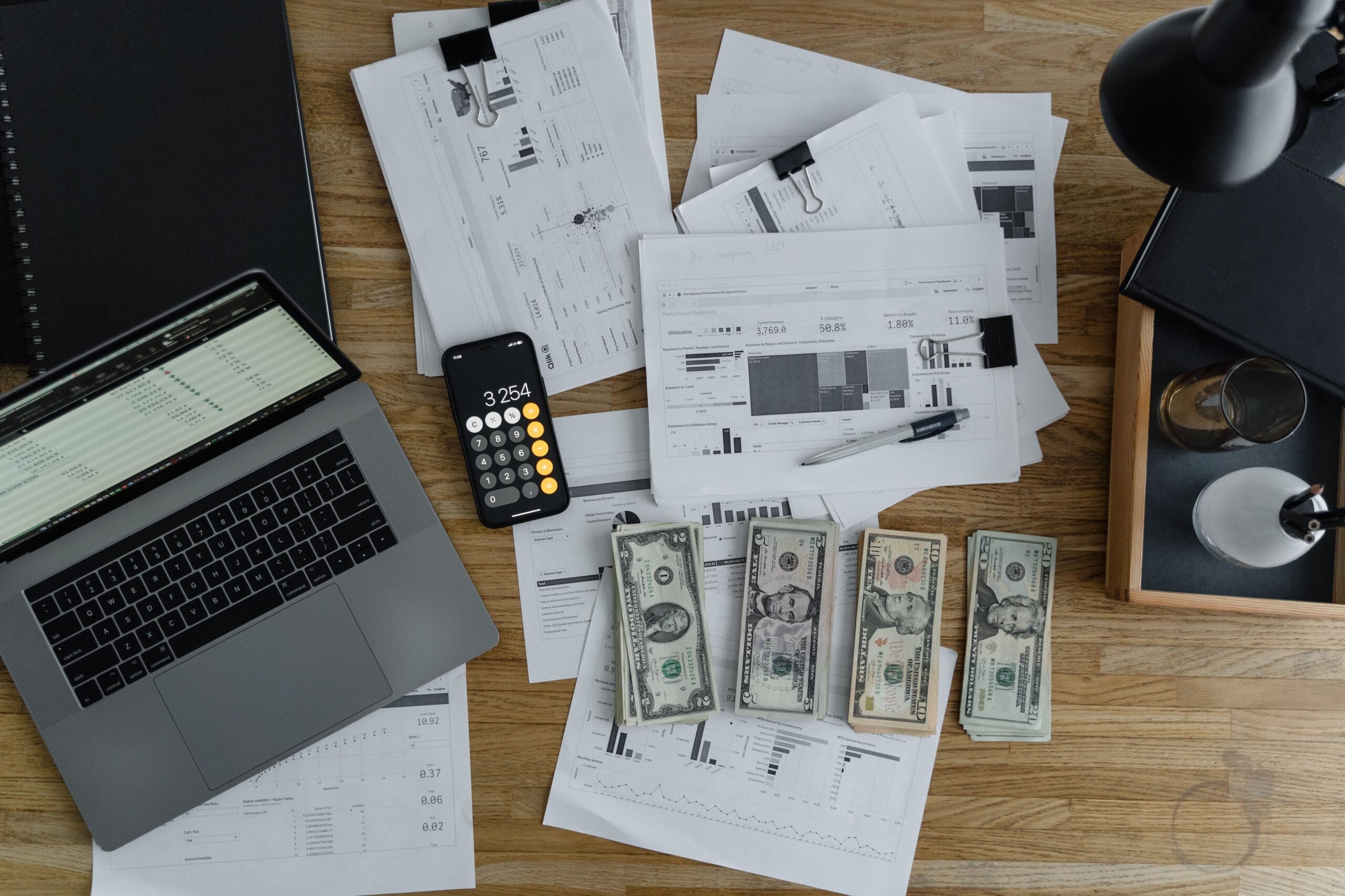 payroll for small business documents with money, calculator and laptop